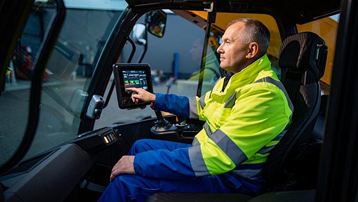 Кабина погрузчика с оператором за цифровой панелью управления
